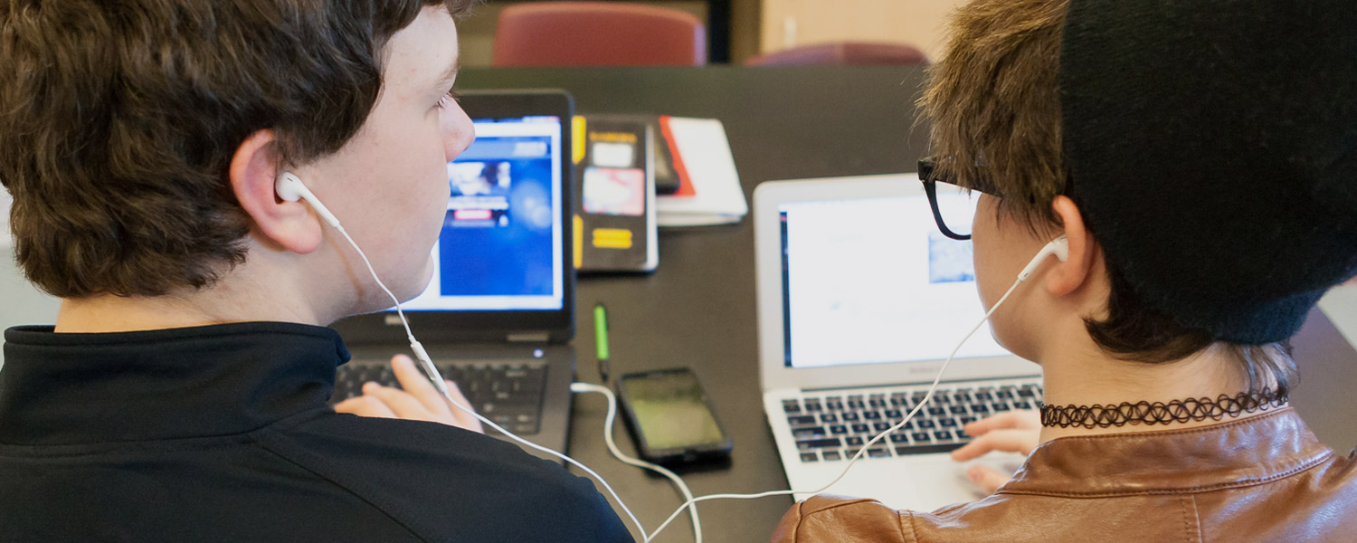 Teenagers talking and looking at a computer together