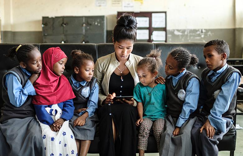 A photo of teacher and students reading representing Celebrating the Importance of Books