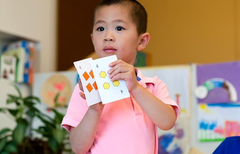 A photo of a young child doing math representing Learning Math with Your Preschoolers: Fun in the Talking and the Playing