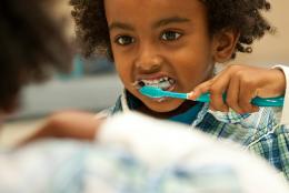 Picture of a young child brushing her teeth.