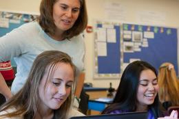 Students and teacher using a computer in the classroom.