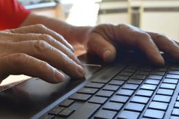 A photo of a person typing on a keyboard.