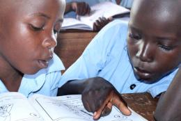 Students reading from a book.