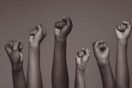 A photo of raised hands representing Lift Every Voice