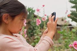 A photo of a child with a phone representing EDC Talks: Unlocking the Potential of WhatsApp in Learning