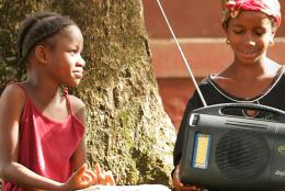 A photo of a teacher and student using a radio