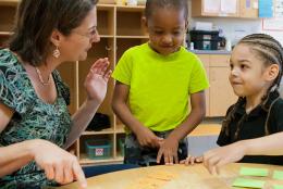 A photo of EDC's Kristen Reed playing a math game with children.