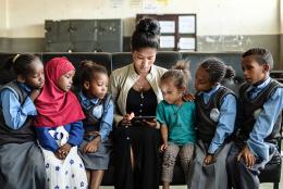 A photo of teacher and students reading representing Celebrating the Importance of Books